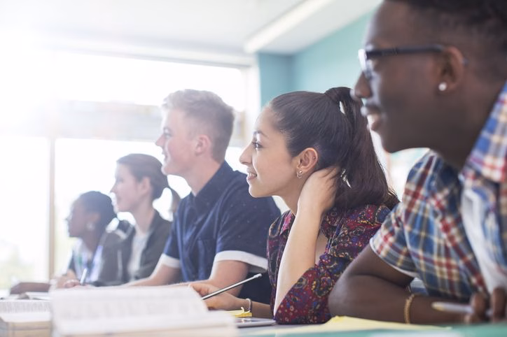 College students sitting and learning in a classroom.