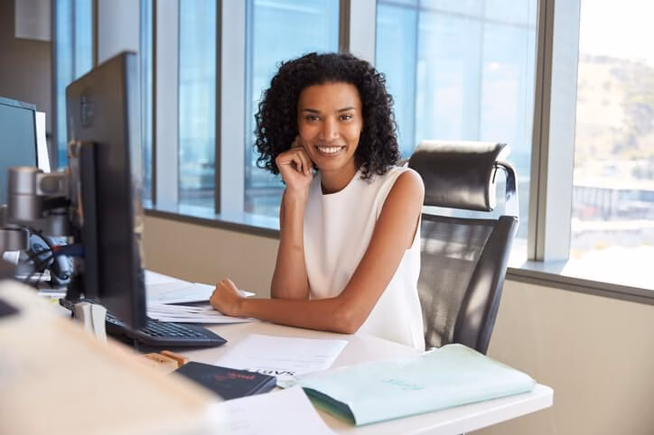 A smiling female medical office specialist in an office after completing her medical office specialist training